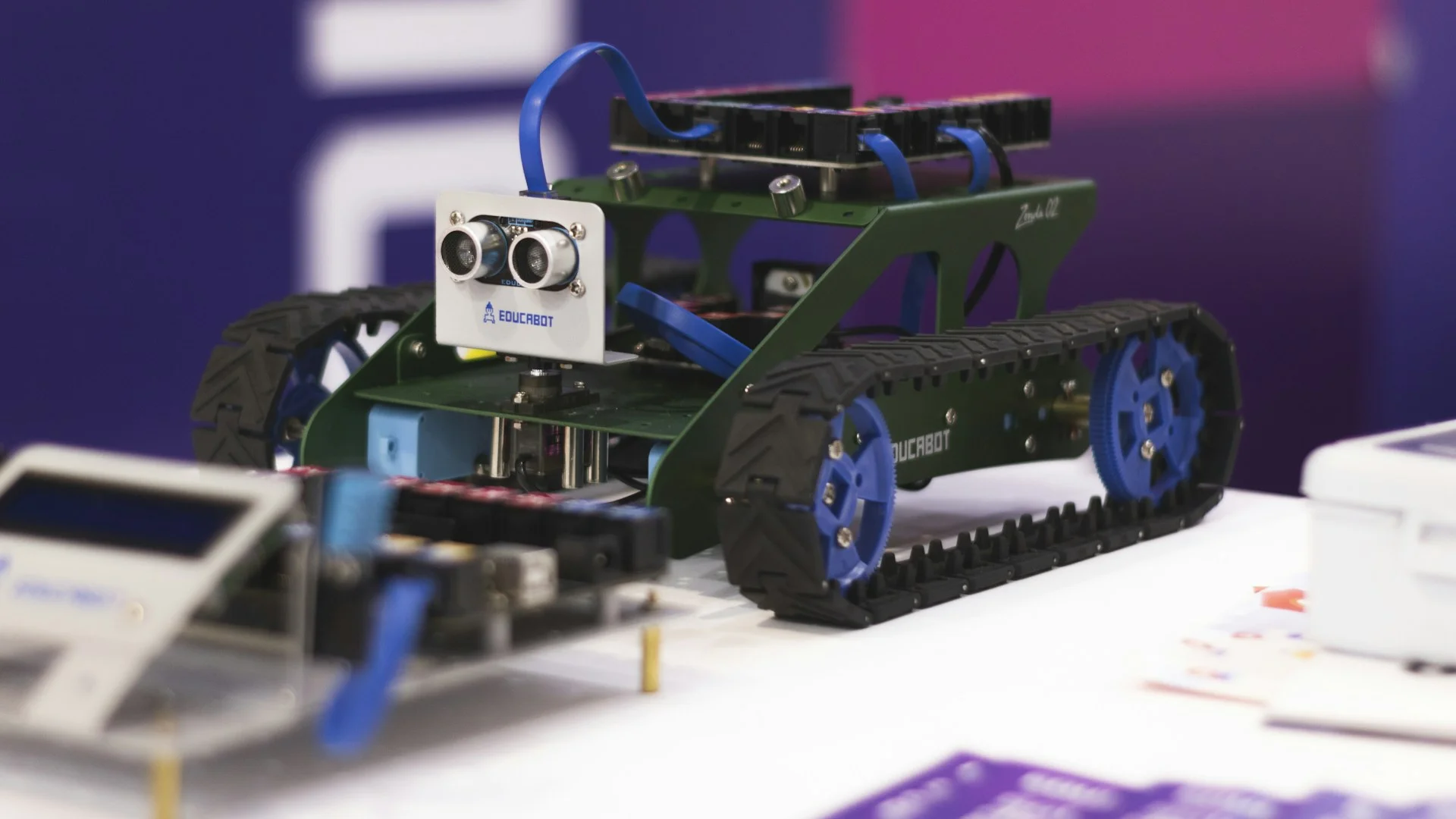 Estudiantes y docente en taller de robótica con prototipos, sensores y impresión 3D — AJTecnology